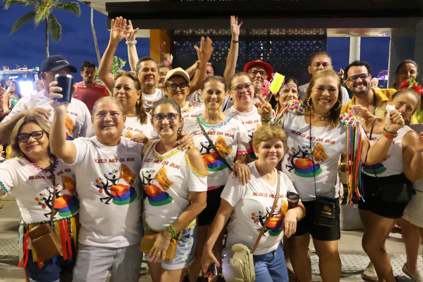 grupo de pessoas posa para a foto no calçadão da praia de iracema. Todos vestem camisas iguais